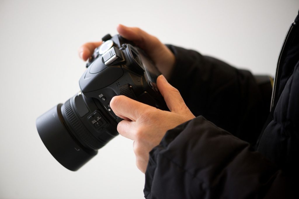 Hands Adjusting Camera Settings