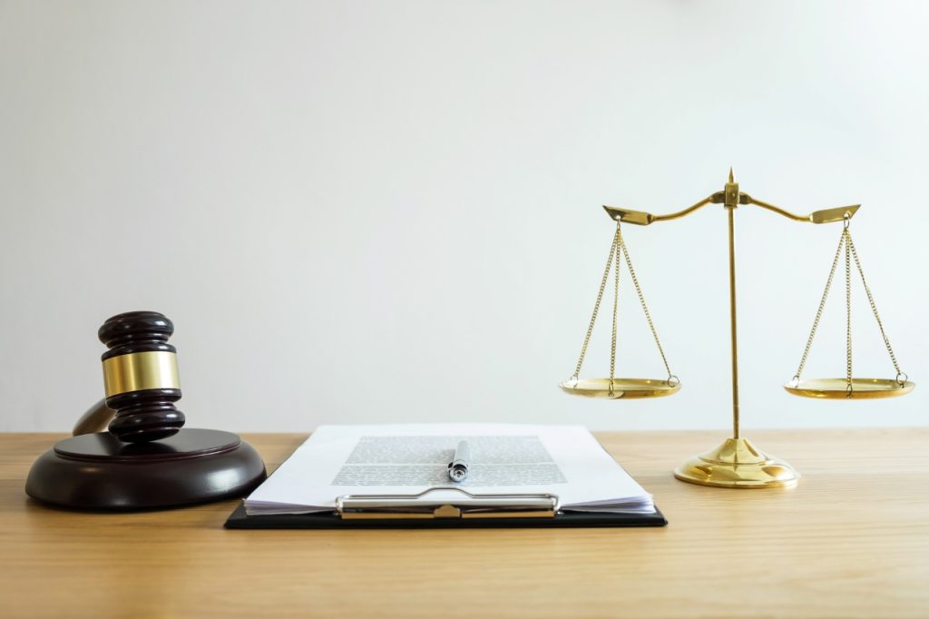 gavel and scale on top of a wooden table