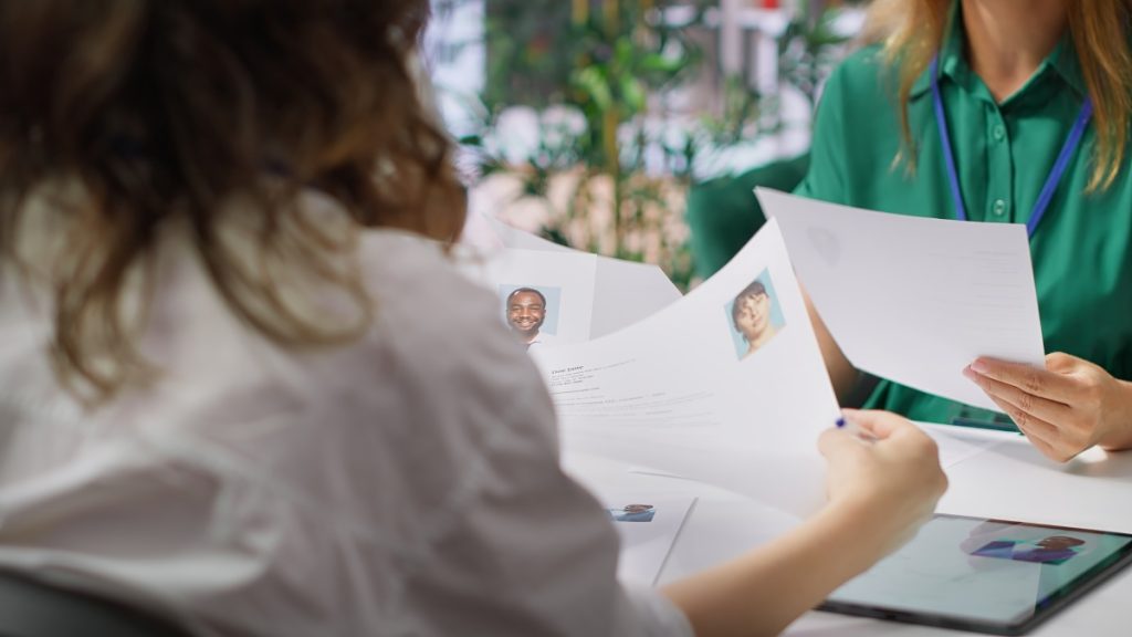 two person reviewing other people's profile on paper