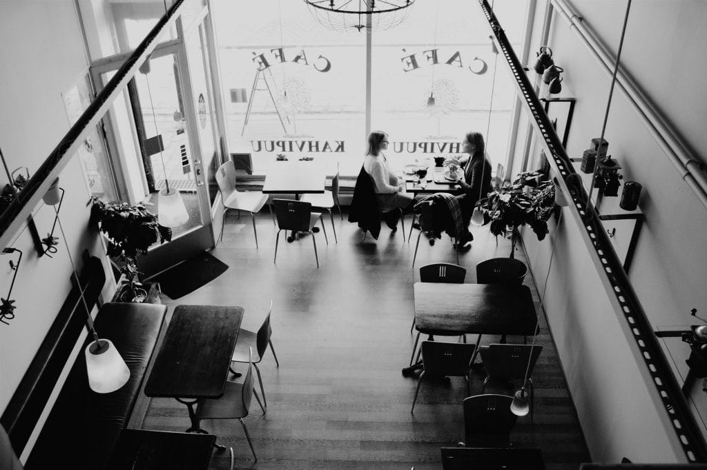 overhead view of a quiet modern café interior with a few empty tables and chairs