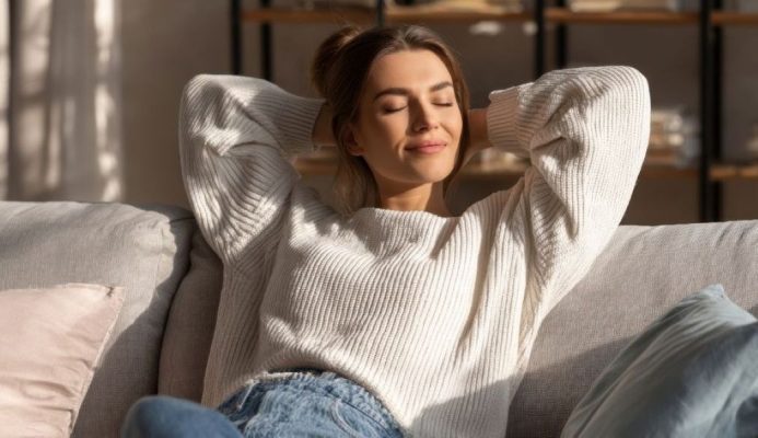 woman enjoying a serene moment of relaxation on a cozy couch